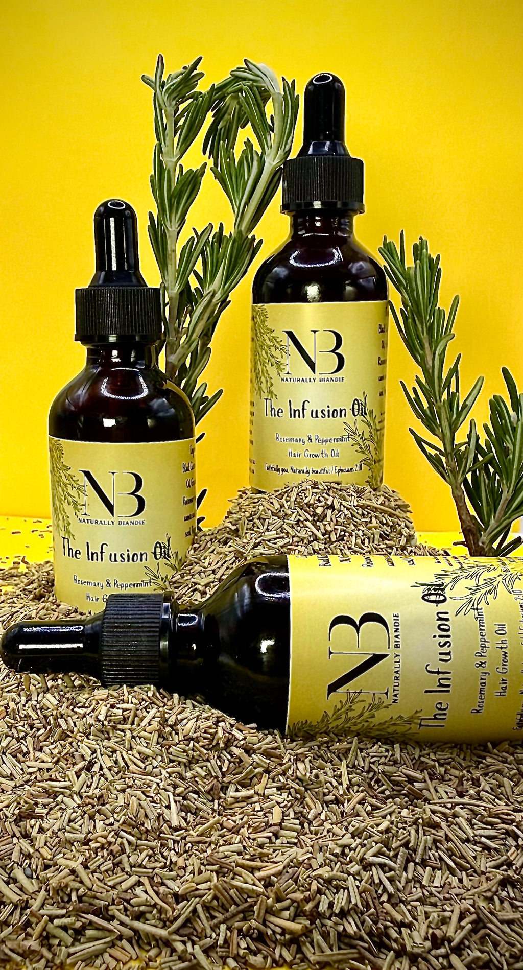 Three bottles of 'The Infusion Oil' with rosemary leaves on a yellow background