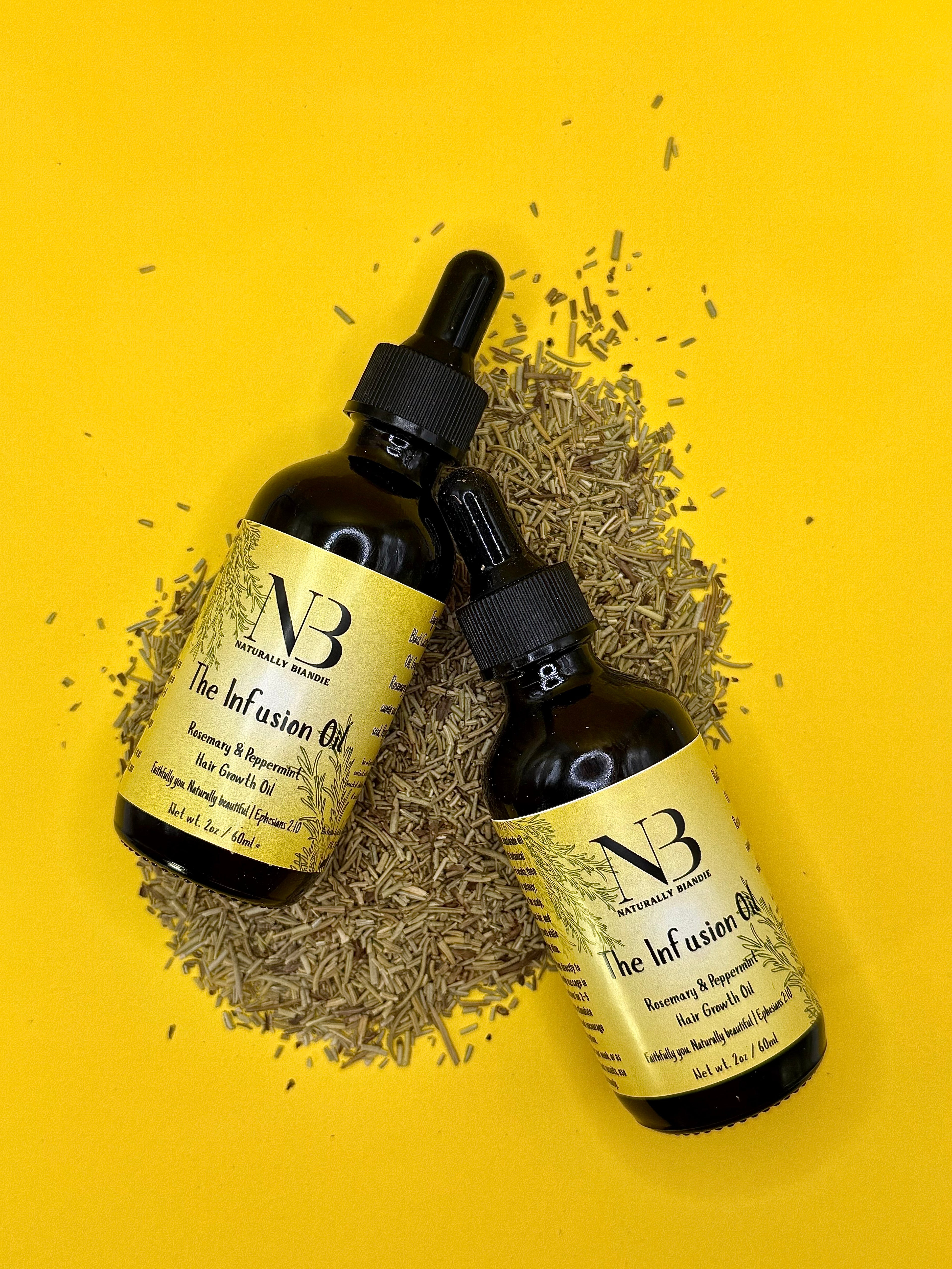 Two bottles of Naturally Biandie Infusion Oil on a yellow background with rosemary herbs.